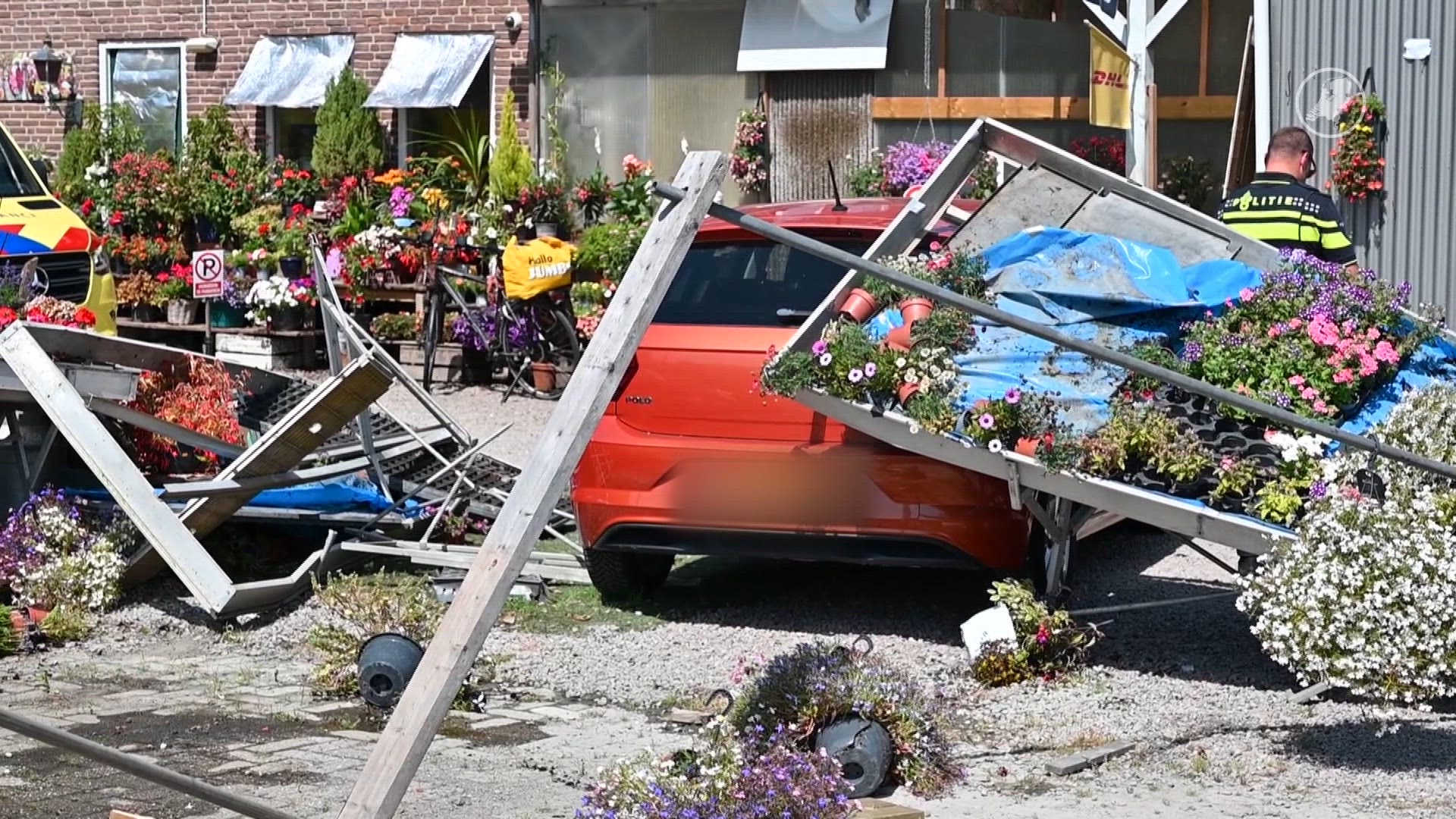 Ravage bij tuincentrum: auto rijdt dwars door plantenbakken heen